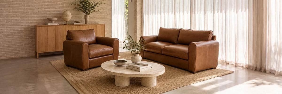 Tan leather Moran sofa and armchair in a sunlit living room